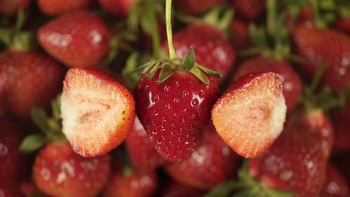 Saftige Beerenfrüchte auf einem Hintergrund aus rotierenden Erdbeeren.