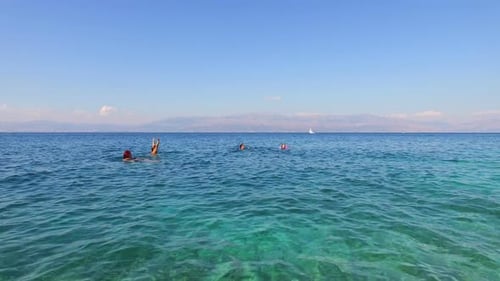 Family having fun swimming in turquoise sea