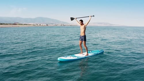 Man Paddle Boarding on Ocean During the Daytime