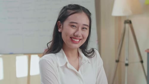 Close Up Of Asian Woman Crossing Arms And Smiling To Camera While Working With Documents
