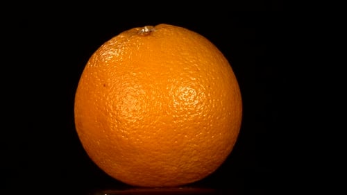 Ripe Orange Rotating Against Black Background