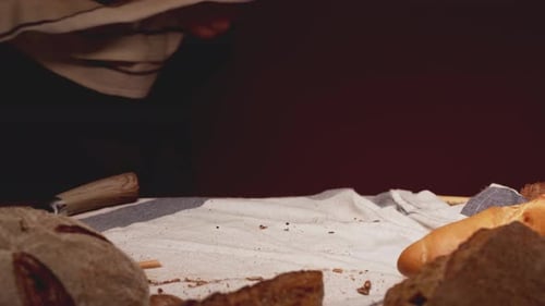 Baker Putting Freshly Made Bread on Table