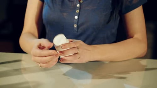 Woman Takes Pill from Bottle