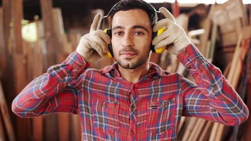 Carpenter Putting on Yellow Safety Ear Protection