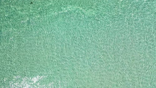 Weitwinkel über der Insel Blick auf einen weißen Sandstrand im Paradies und blauen Ozeanhintergrund in lebendigem 4K