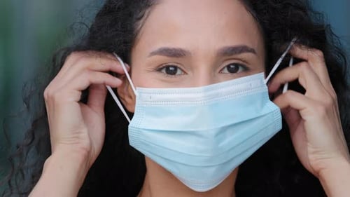 Woman Puts on Mask and Gives Thumbs Up