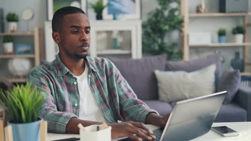 Man works at laptop in living room setting