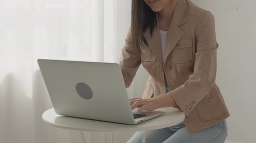 Young asian businesswoman working on laptop computer on desk at home office.