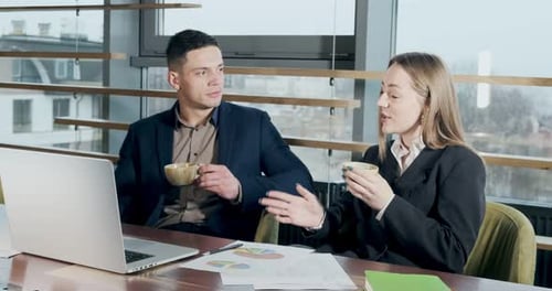 Man and a Woman Discussing Work in the Brightly Lit Modern Office. Male and Female Working with