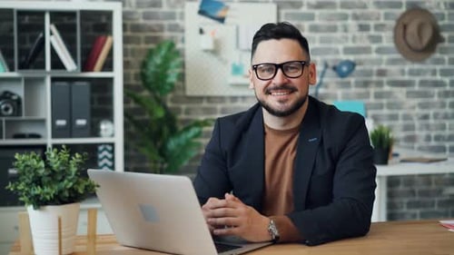 Smiling Man at Desk in Modern Office