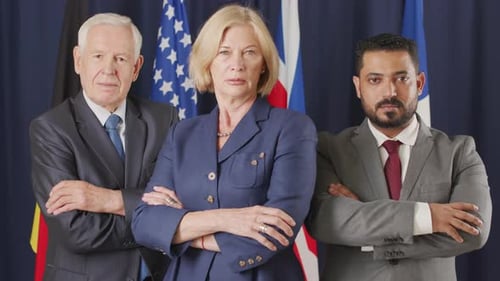 Serious Adults in Suits Standing Before International Flags