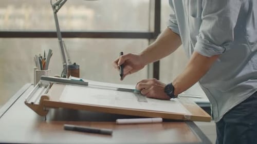 Architect Designing Plans on Drafting Table