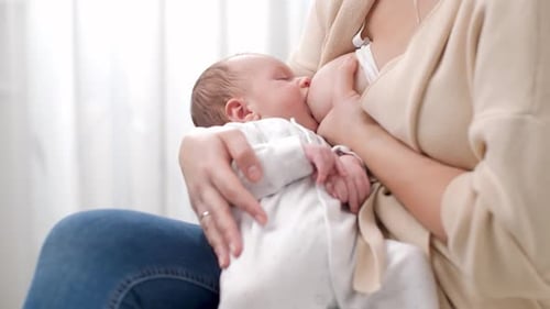 Tender Mother Breastfeeds Her Newborn Baby at Home