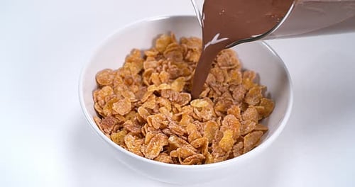 Chocolate Milk Poured Over Cereal in White Bowl
