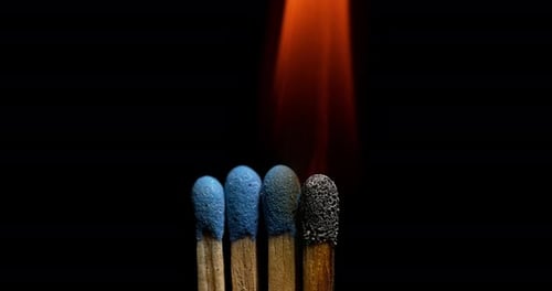 Match Burning in Macro Shot Against Black Background