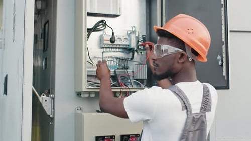 Electrician Testing Control Panel with Multi-Meter