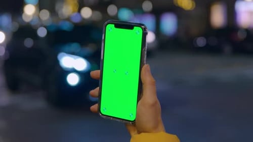 Woman Hold Green Screen Phone in Hand at Night