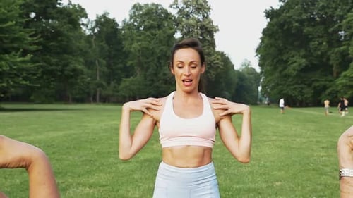 Fitness Class Doing Arm Stretches in Park