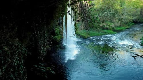 Lush Waterfall Flowing into Tranquil River