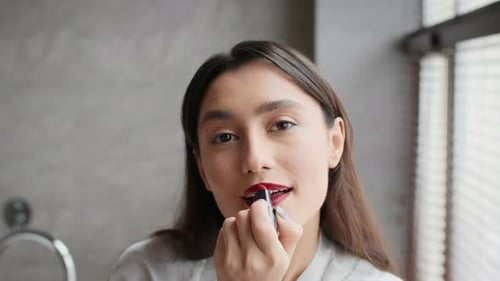 Attractive Brunette Lady Applying Bright Lipstick Making Makeup In Bathroom