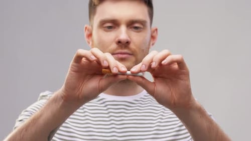 Young Man in Striped T-shirt Braking Cigarette
