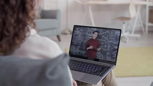 Person Watches Instructor on Laptop During Online Class