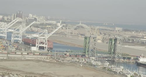 Aerial View of Busy Harbor with Cranes and Bridges