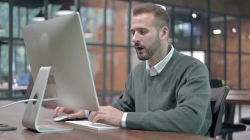 Gestresster Mann wird schockiert, während er am Computer arbeitet