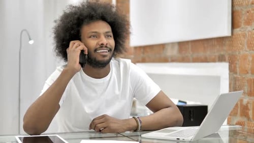 Young Adult Using Smartphone at Desk