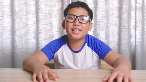 Teen Boy Talking at Wooden Desk in Home