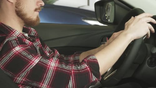 Man With Beard Sits in Driver's Seat of Car