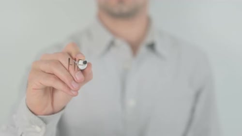 Hand Writes Health Insurance on Clear Surface