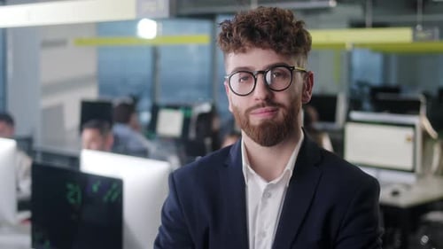 Porträt eines fröhlichen männlichen Chefs in Jacke und Brille mit Blick in die Kamera und Lächeln