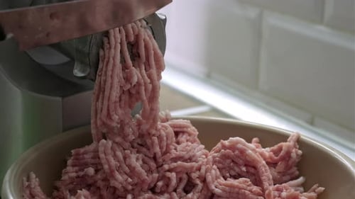 Closeup Process of Meat Grinding in the Kitchen with Mincing Machine