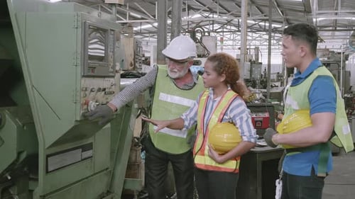 Group of engineer talking and training working using machine control together in industrial factory.