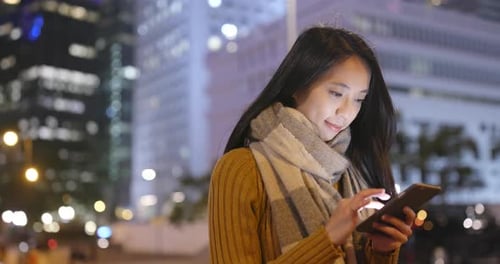 Woman Use of Smart Phone in Hong Kong City at Night