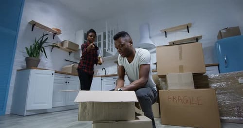 Couple Packing Belongings into Boxes in New Home