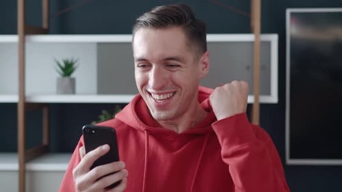 Excited Man Reacting to Good News on Smartphone