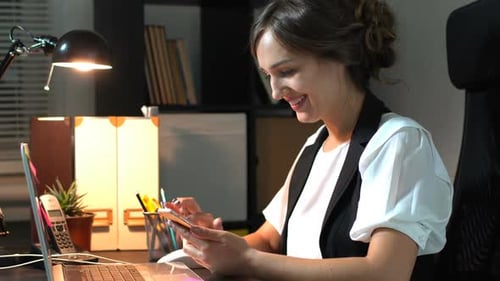 Businesswoman Sitting At Her Workplace In Office And Use Smart Phone