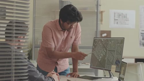 Diverse Engineers Examining City Map in Office