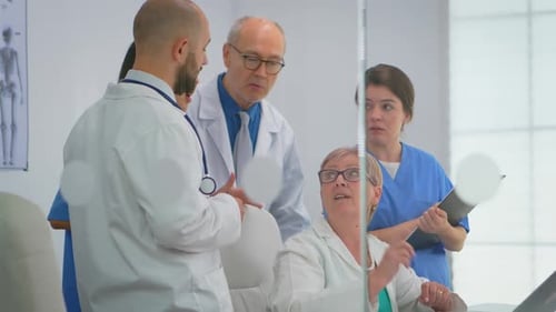 Team of Doctors Standing in Conference Hospital Room Using Laptop