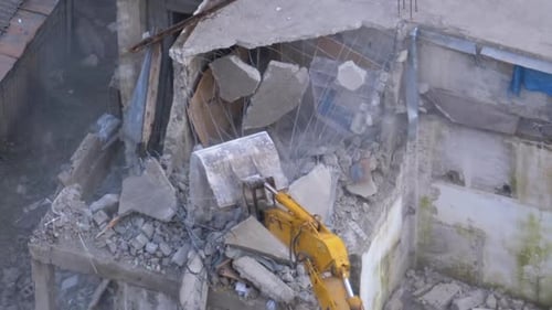 Excavator Demolishing Damaged Building in Urban Setting