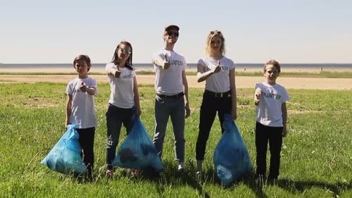 Front View of Young Family Recycle Plastic Bottle Volunteers Posing and Gesturing with Garbage Bags