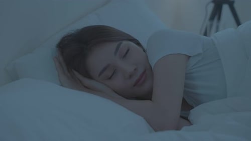 Asian beautiful woman lying down on bed in bedroom, dreaming at night.