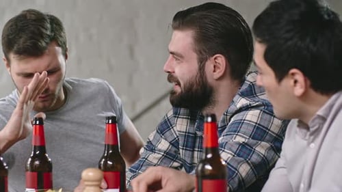 Young Adults Socializing Over Beer at a Table