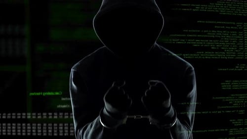Hooded Person in Handcuffs with Computer Code Background