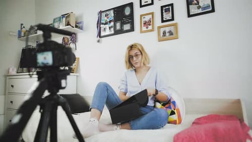 Young Woman Unboxing Products On Camera At Home