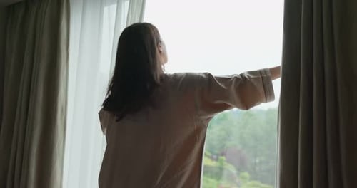 Woman Opens Window to Beautiful Morning View