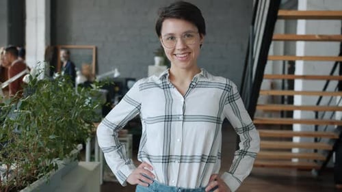 Portrait of Joyful Girl Office Worker Standing in Modern Coworking Room Smiling Looking at Camera