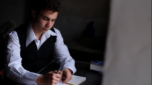 Young Adult Writing Notes in Notebook